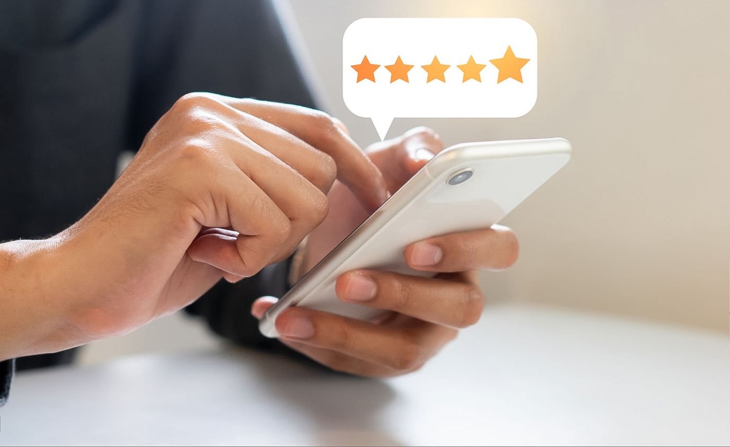 Hands holding a white smartphone with 5-star rating icons displayed above, indicating positive customer feedback.