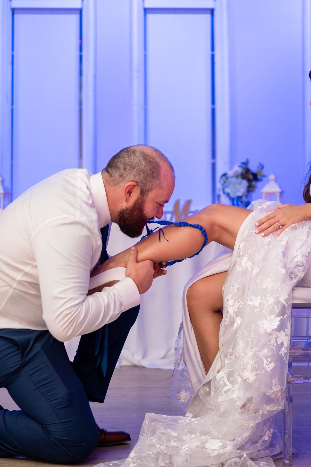 A romantic wedding couple performs different dip poses in a sequence of four connected photos against a blue background.