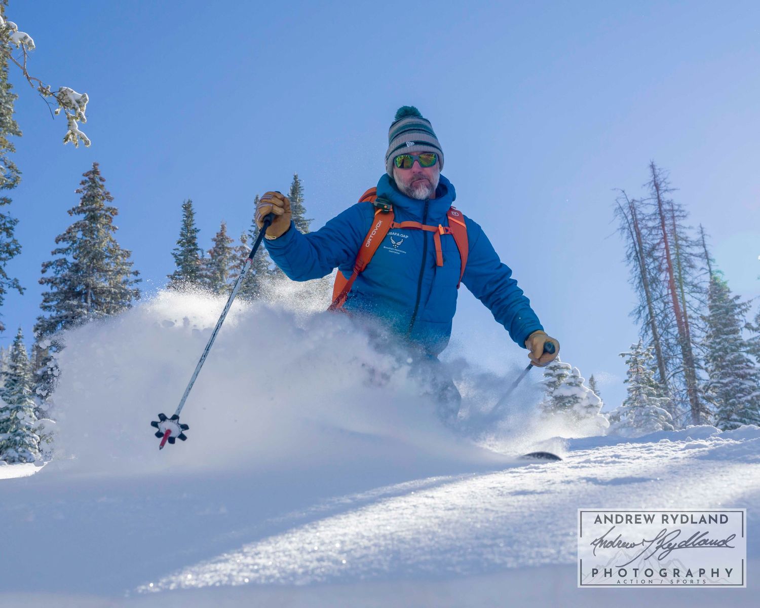 Skier gliding through deep powder snow on sunny winter day.