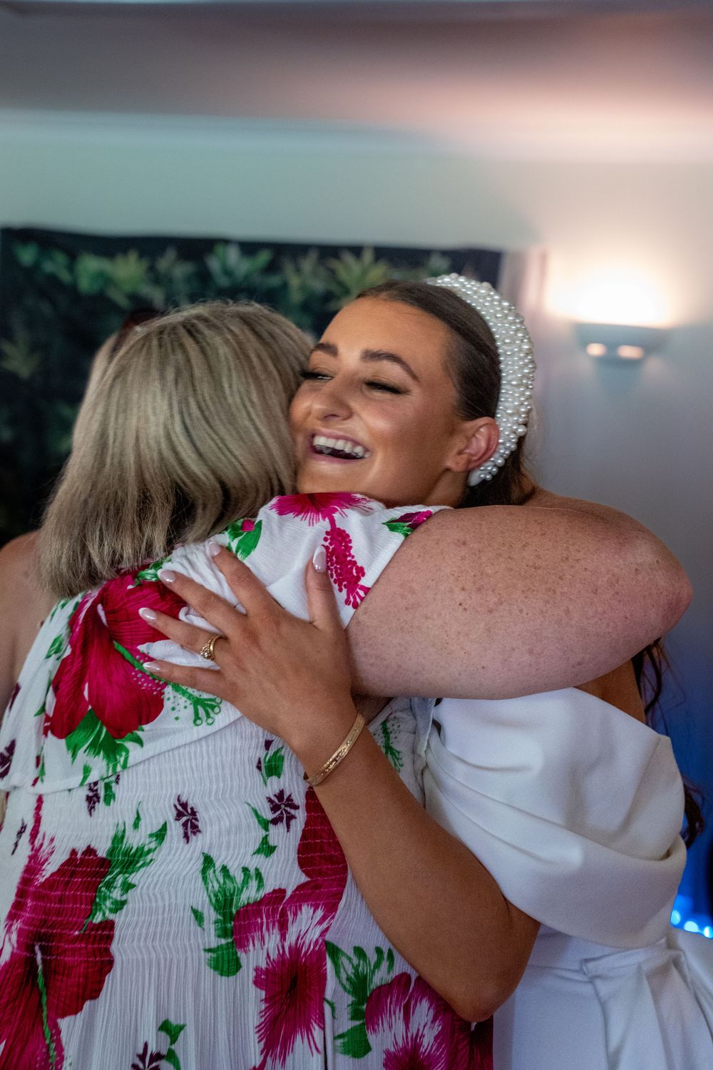 A sequence of emotional embraces between people in formal attire sharing joyful hugs at a celebratory event.