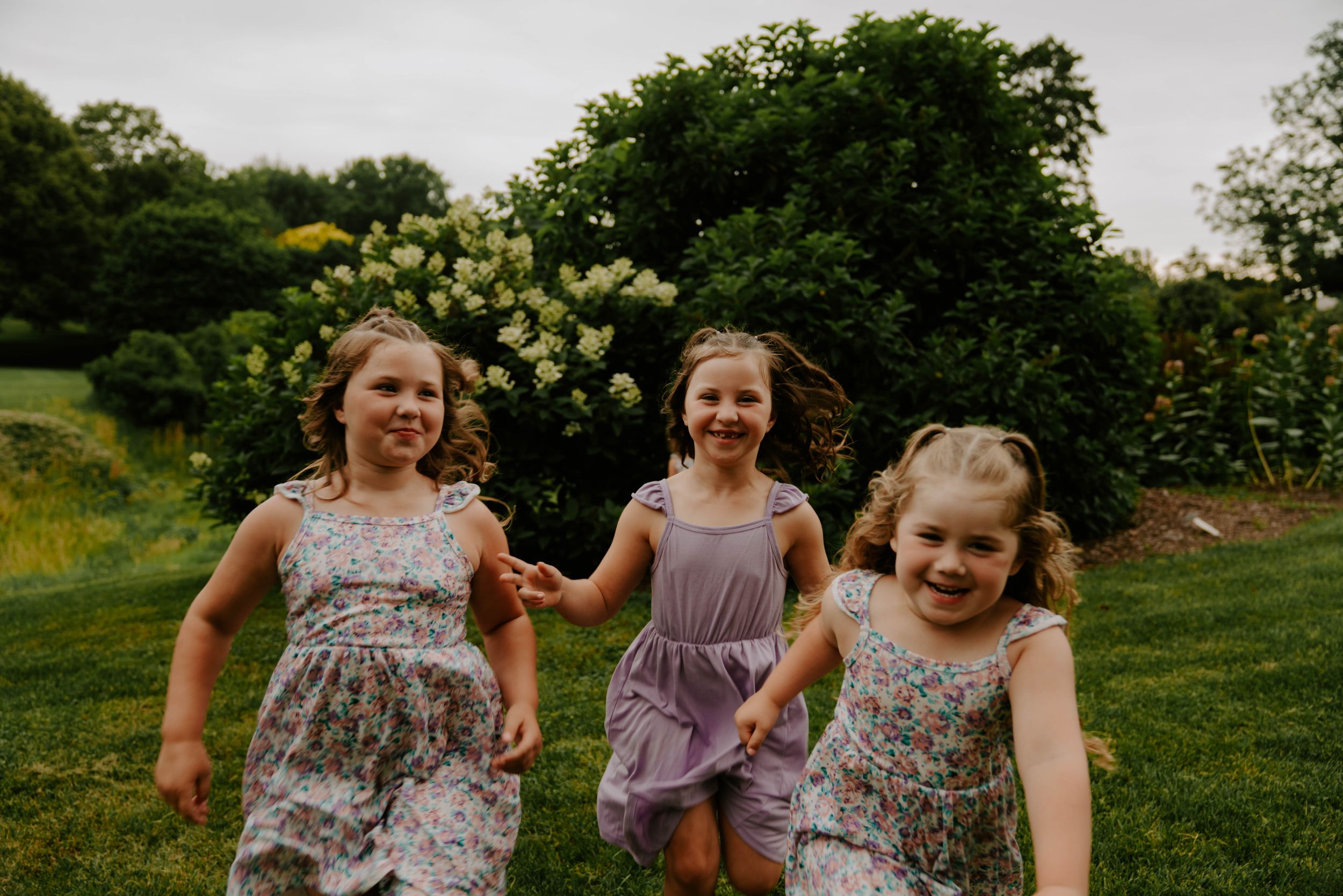 Candid moment captured of group running and playing on grassy hill.