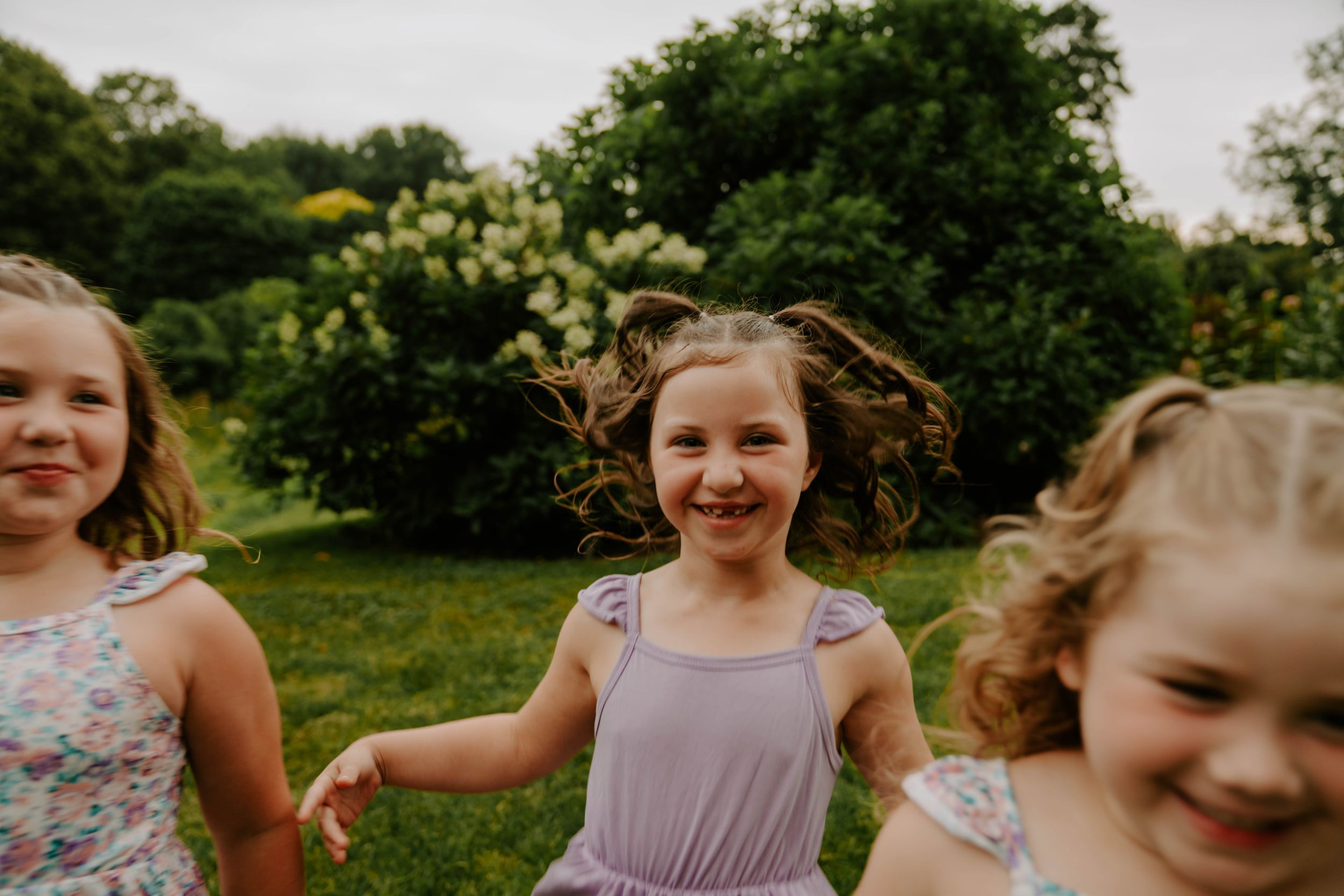 Joyful outdoor portrait session with coordinated floral and lavender outfits.