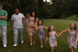 Family members arranged in a line outdoors wearing coordinated summer outfits.