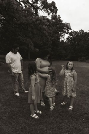 Black and white photo of people posing casually in a grassy outdoor setting.