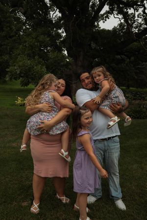 Group embracing in a candid moment outdoors during a photo session.