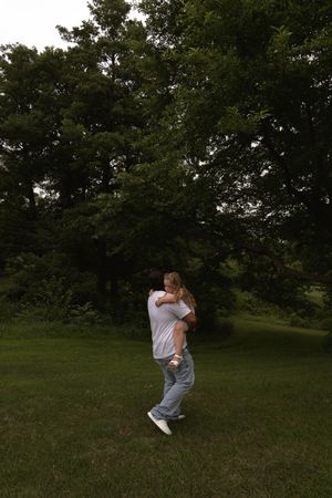 Candid moments captured between people in an outdoor setting with trees.
