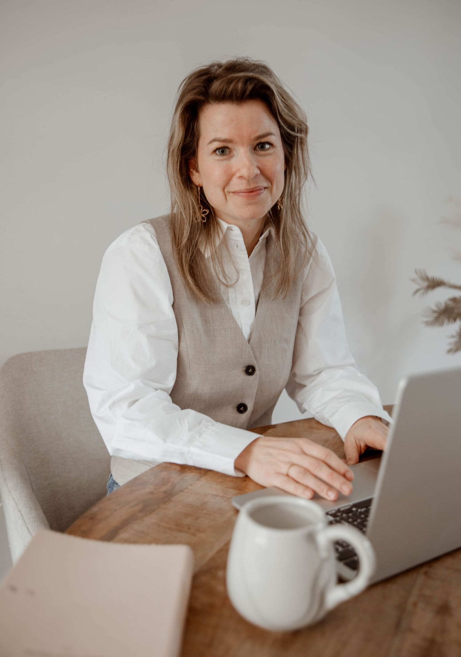 Professional portrait series showing someone working at a laptop with coffee.