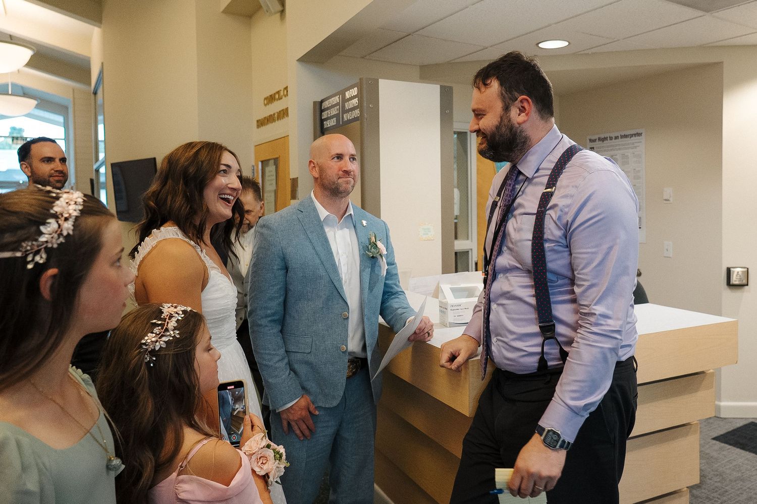 People gathered in a hallway or office space having animated conversations and interactions during a professional event.