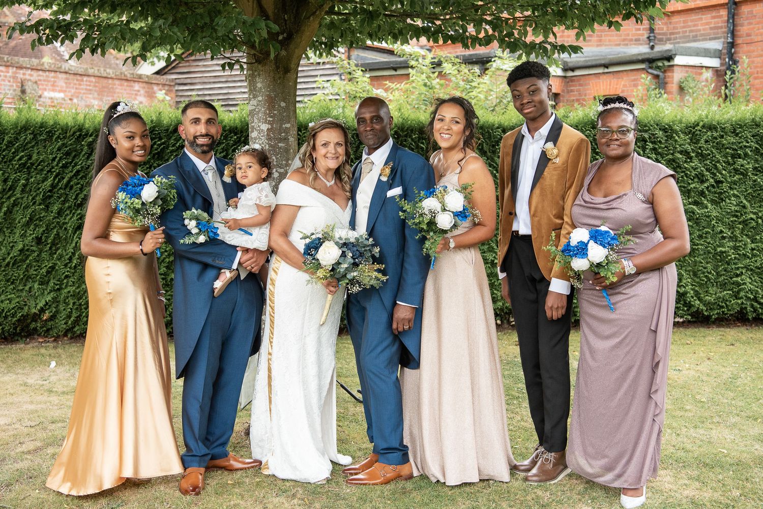 Group wedding photo taken under tree in the rain with bride groom and six of their family