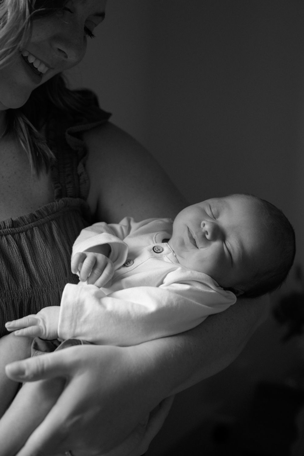 Black and white portrait of a sleeping baby in gentle lighting.