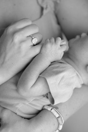 Black and white images of hands with rings and bracelets touching softly.