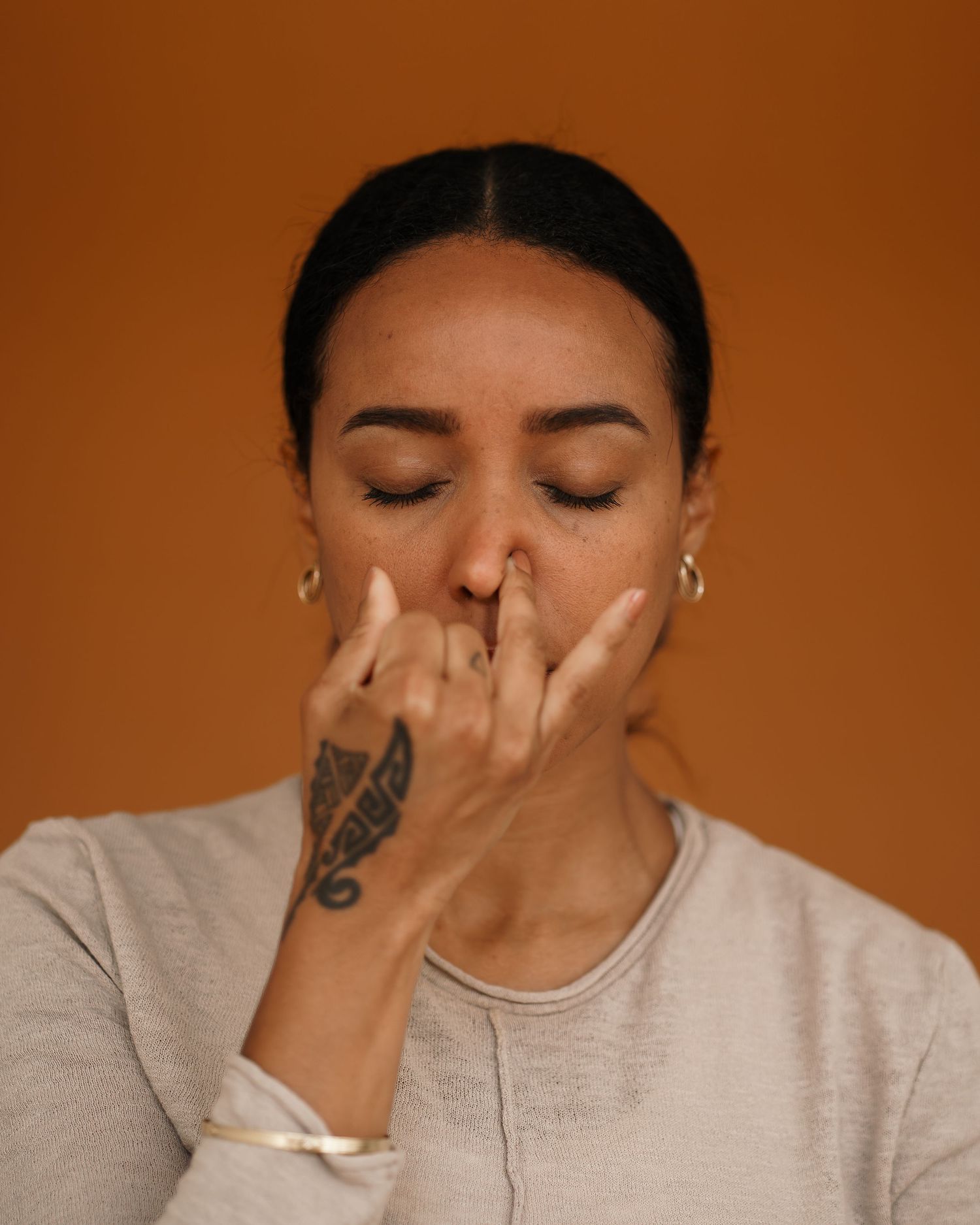 Serene portrait against warm brown background showing mindful moment of reflection.