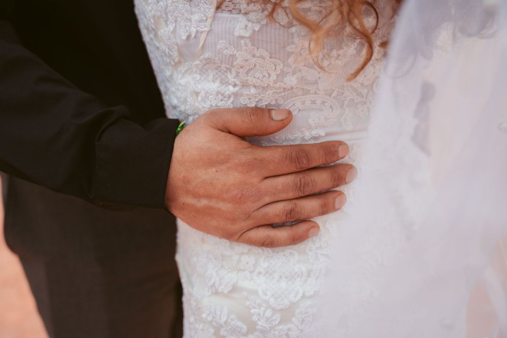 Close-up shot of wedding couple's tender embrace among desert rock formations.