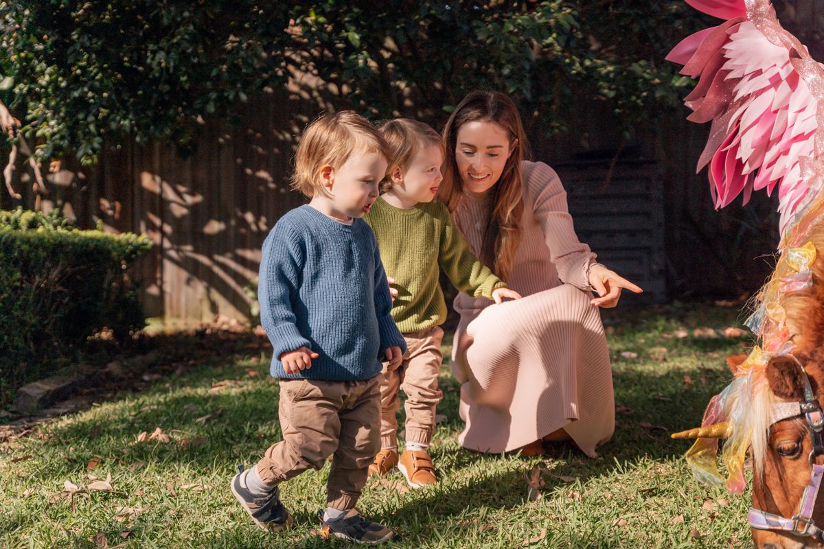 twins and their mom approaching a unicorn during a birthday photoshoot in Lane cove Sydney
