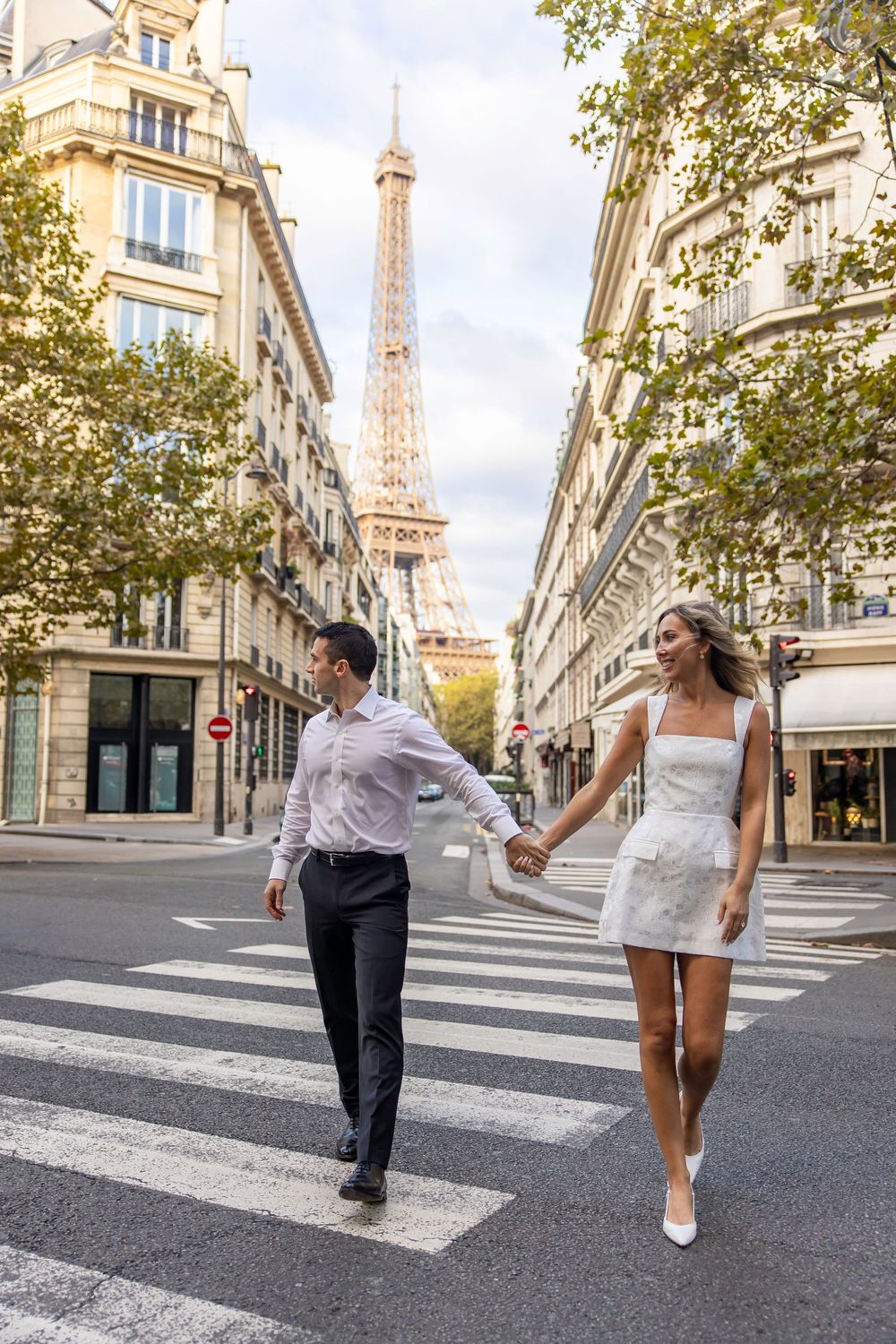 Series of shots capturing two people walking together across a crosswalk with the Eiffel Tower visible in Paris.