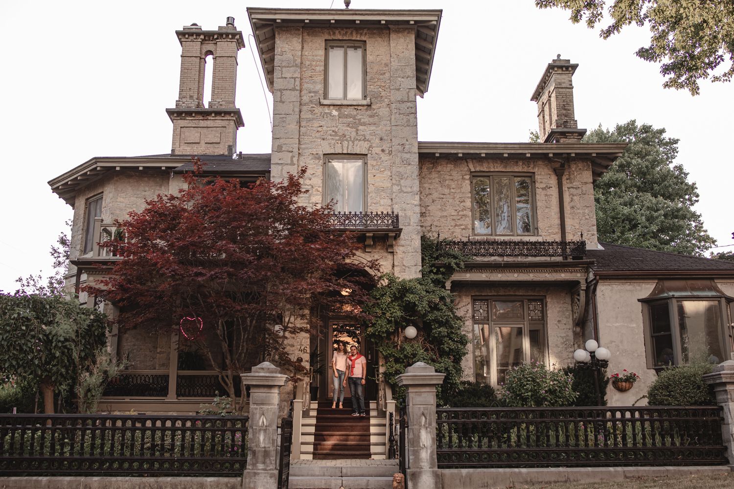 couple standing on the front steps of the rosemont inn, downtown kingston, ontario