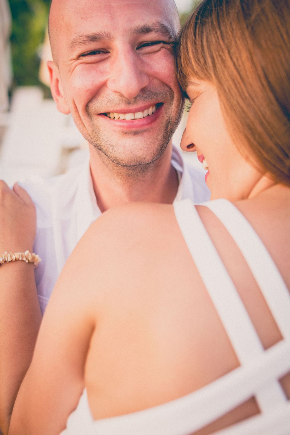 Close-up shots of a romantic couple sharing intimate moments and smiles at a beach resort.