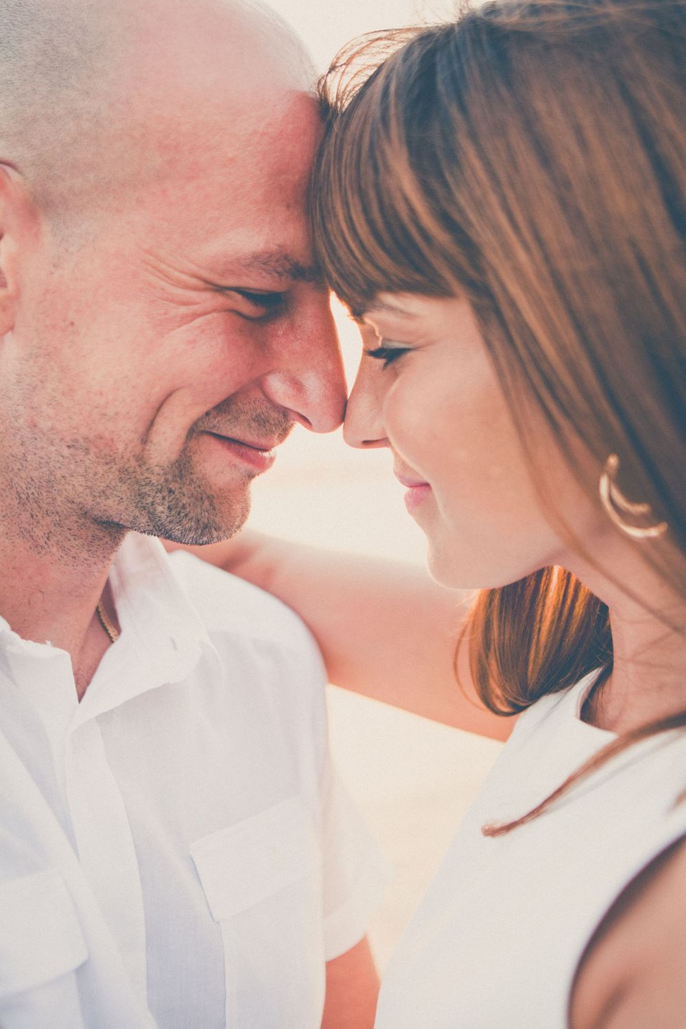 Close up of loving couple sharing tender moment in soft lighting.