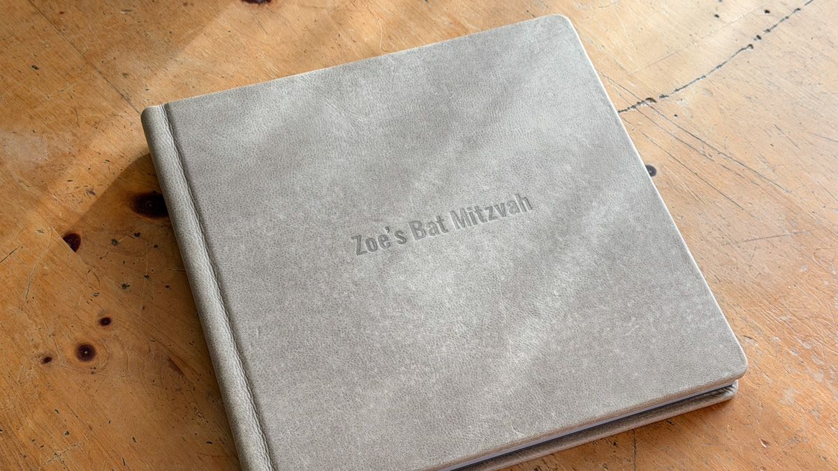 Minimalist gray leather card holders or wallets displayed on a wooden surface with a rustic texture.
