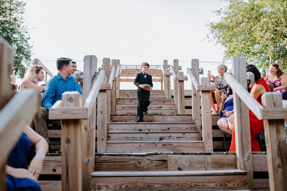Guests gather on rustic wooden stairs during an outdoor event at sunset.