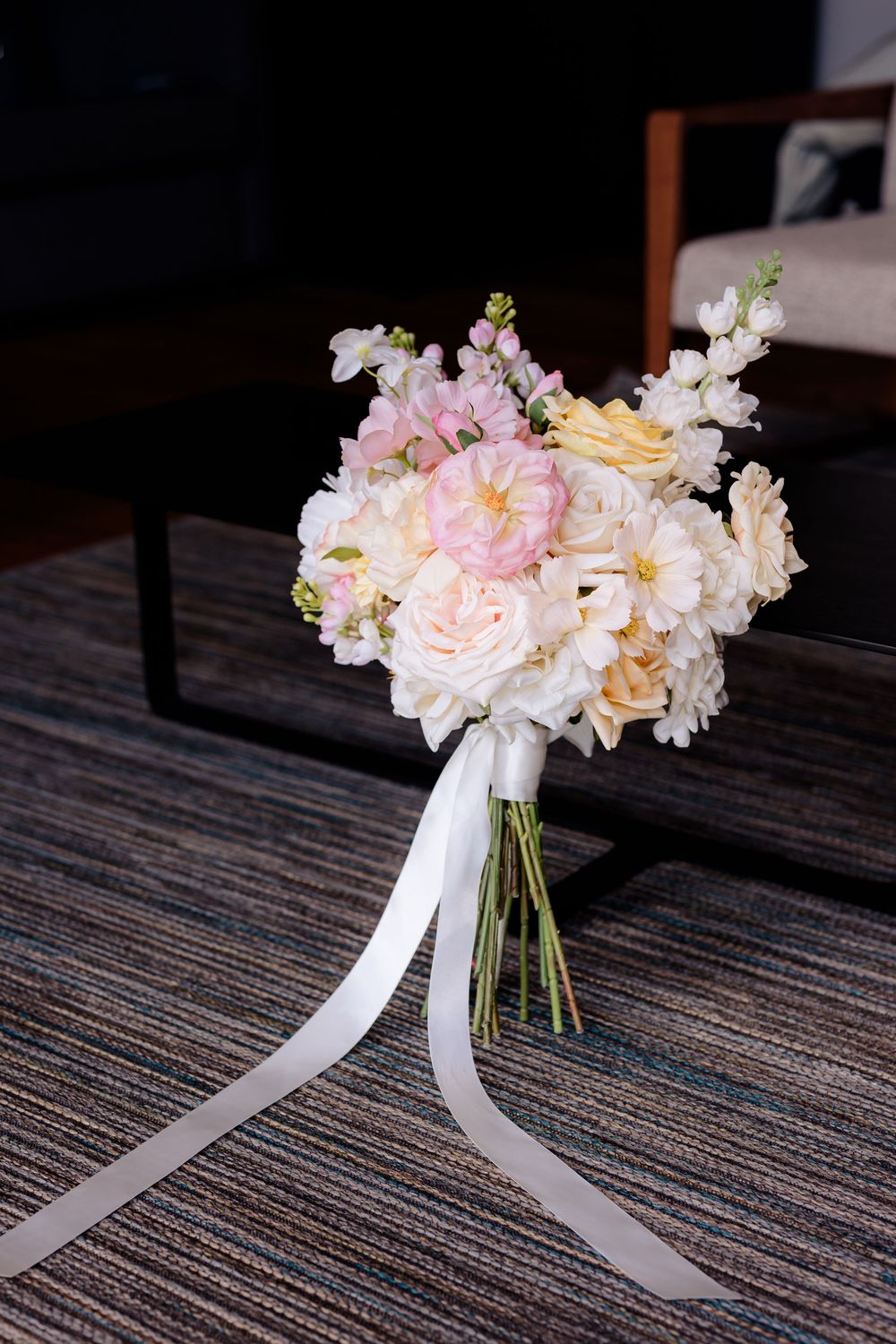 Romantic wedding bouquets with pink and white flowers tied with flowing white ribbons.