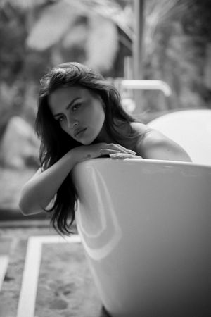Black and white artistic portrait series showing graceful poses and dramatic lighting effects against a light background.