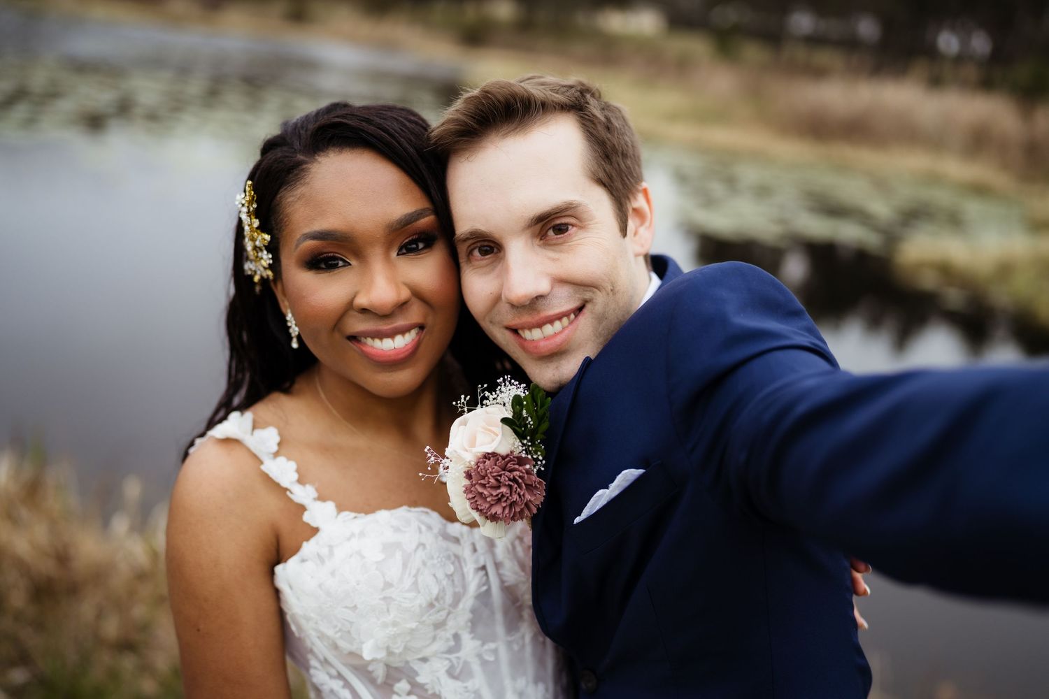 A happy couple in wedding attire embrace outdoors during their special day celebration.