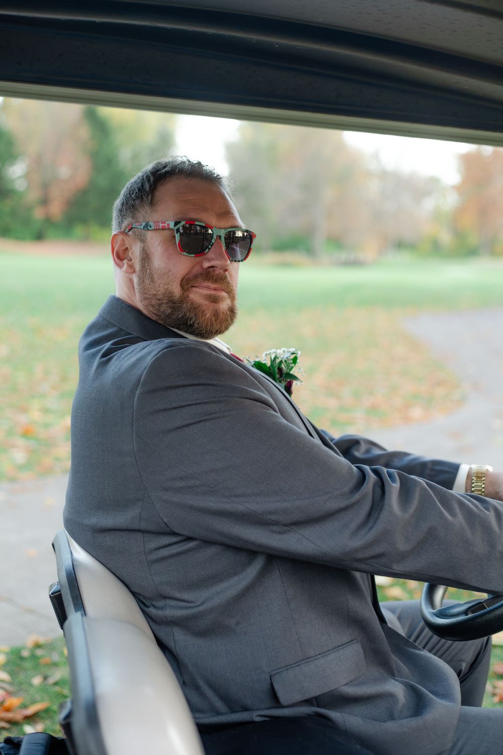 Person in gray suit sitting in driver's seat of vehicle looking over their shoulder in a series of similar poses.