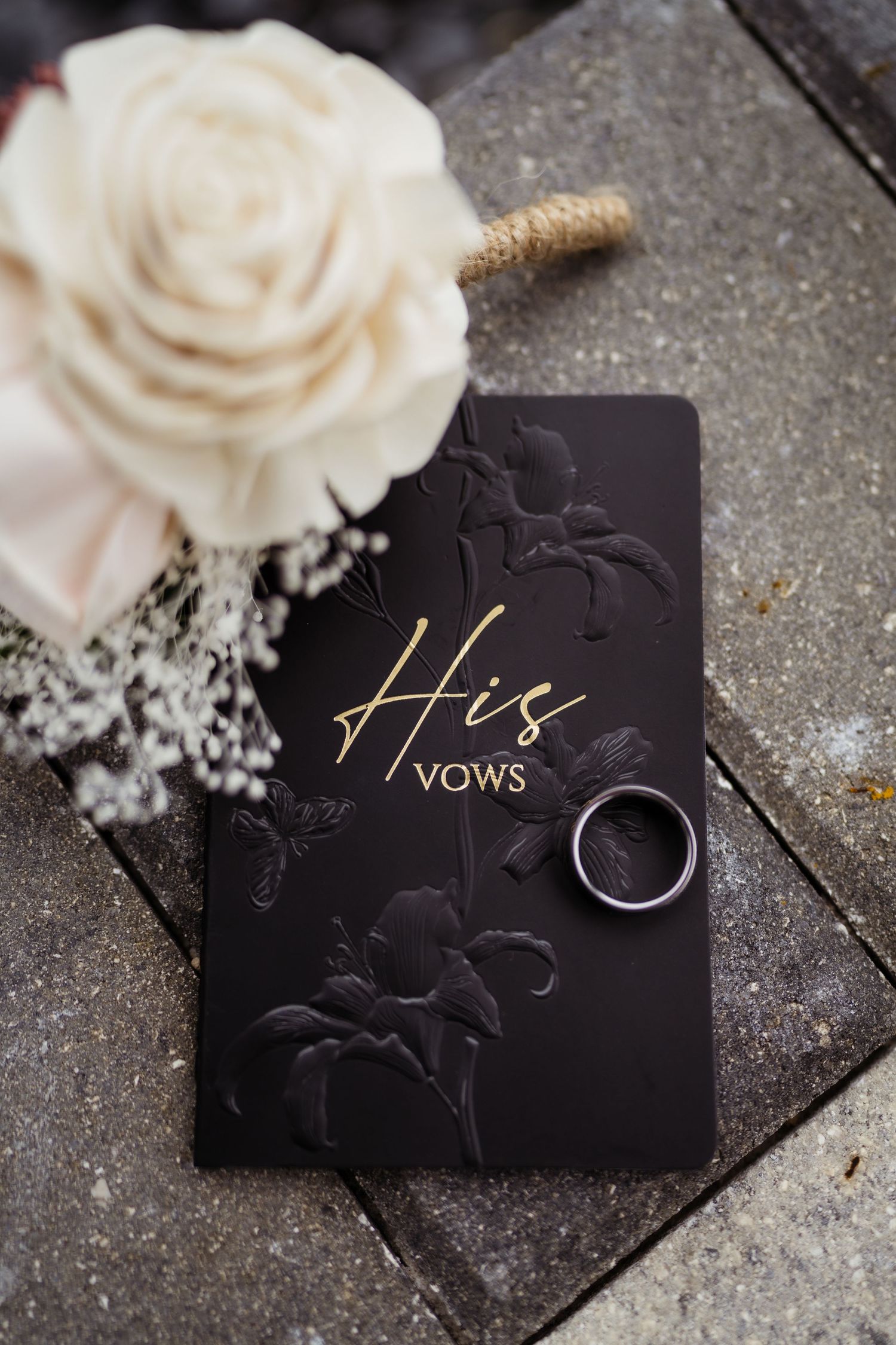 Black wedding vow cards with elegant gold text and white roses create a romantic and sophisticated aesthetic.