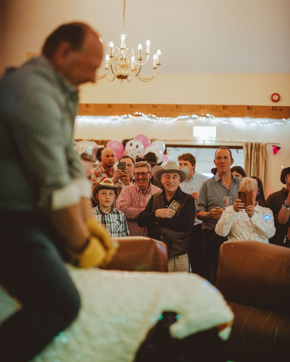 Wedding reception guests watching and celebrating in a warmly lit indoor venue.