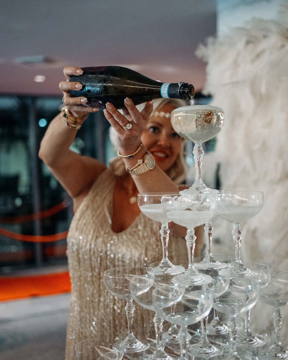 Champagne being poured into a tower of crystal glasses at an elegant celebration.