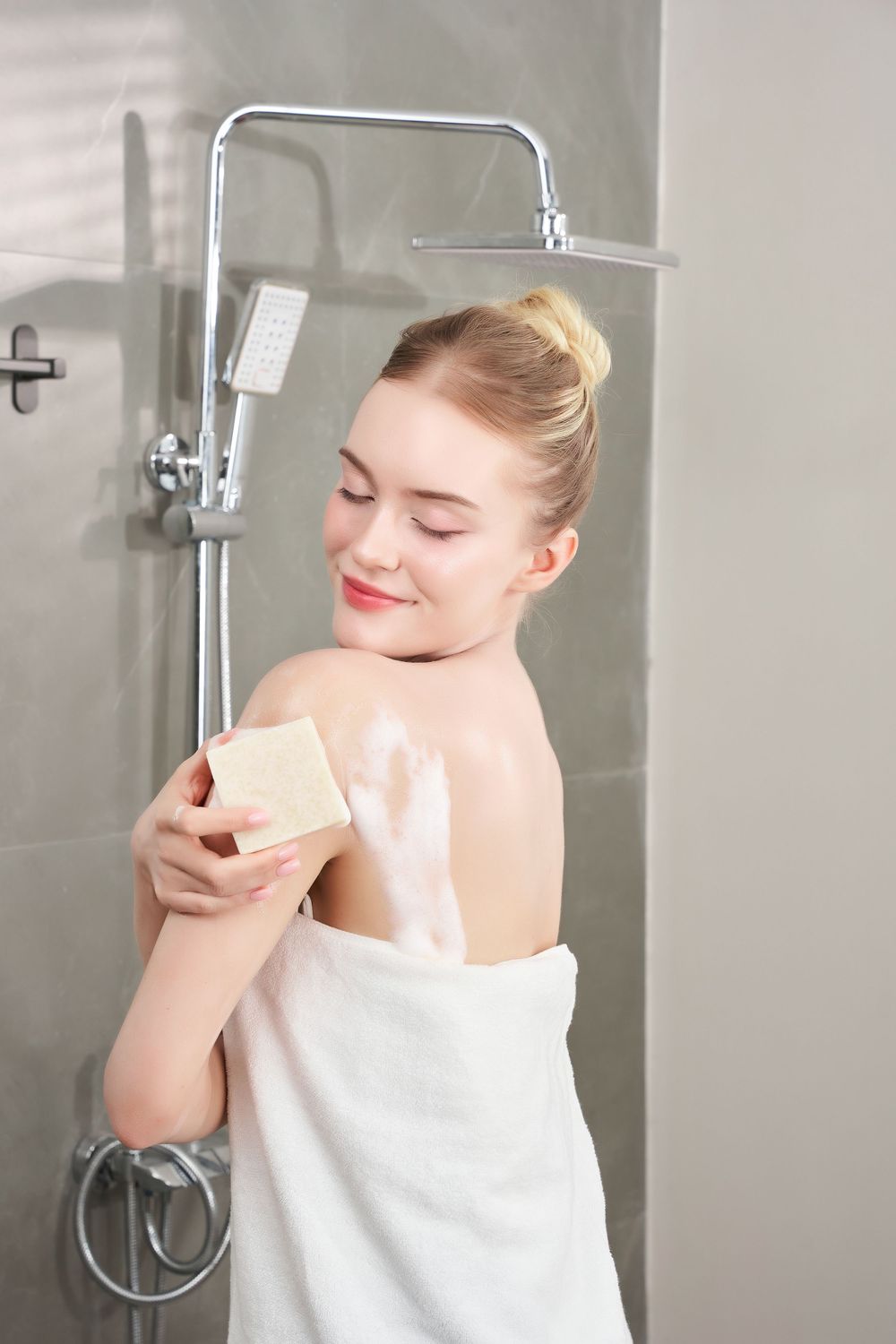 Ảnh chụp model nước ngoài đang sử dụng xà phòng handmade trong không gian nhà tắm hiện đại