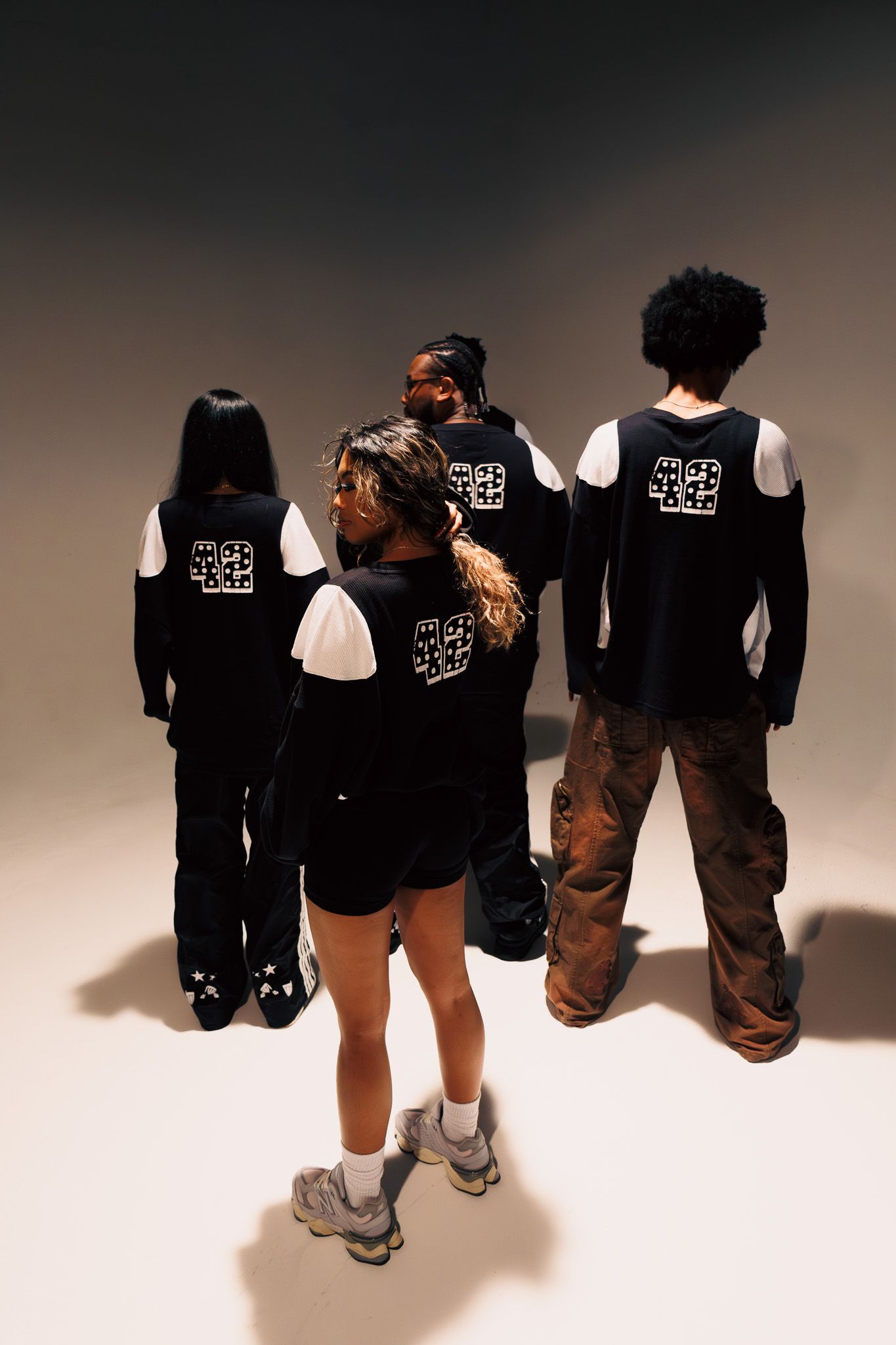 A sequence of photos showing people in black hoodies with white angel wing designs on the back.