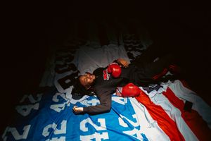 A red and blue striped soccer jersey lies crumpled on a dark surface.