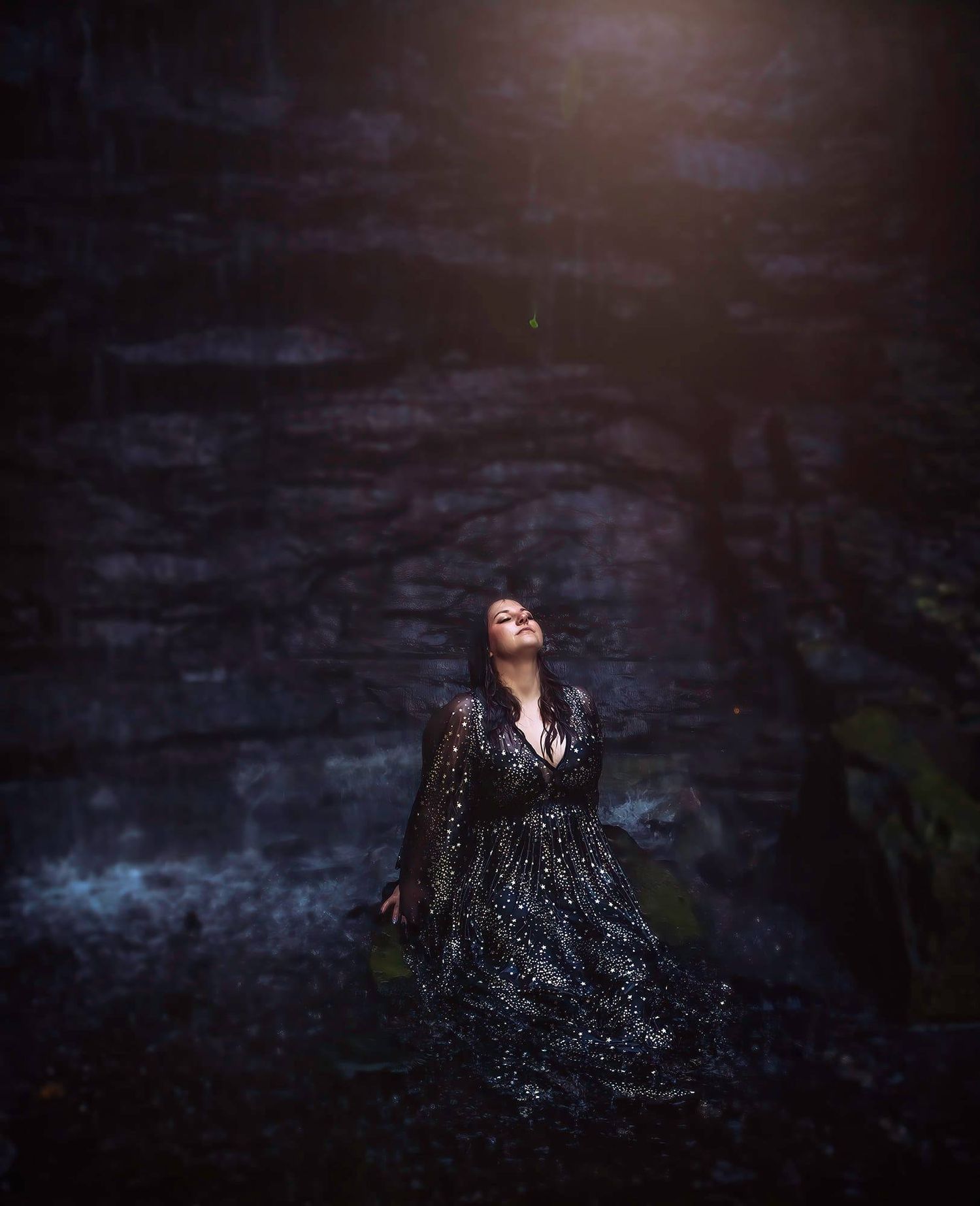 Dramatic portrait in a sparkly dress against a dark moody backdrop.