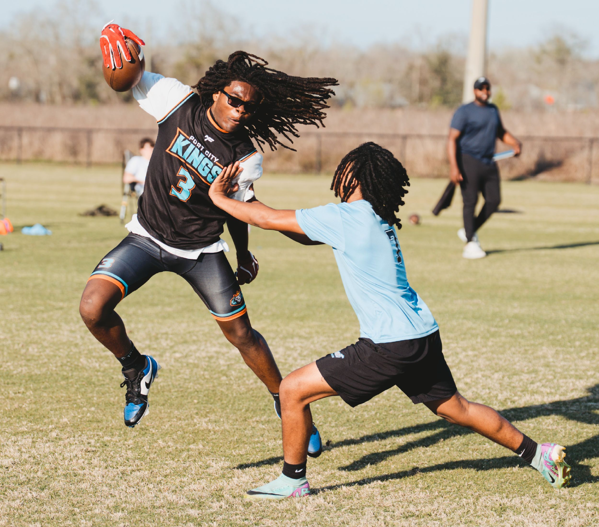 Players diving and reaching for a frisbee during an intense ultimate frisbee match.