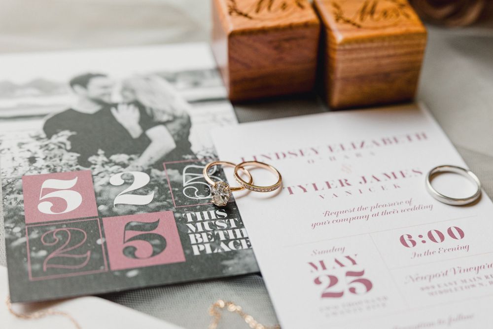 Wedding invitation cards and envelopes with vintage style typography and design elements arranged on a wooden surface.