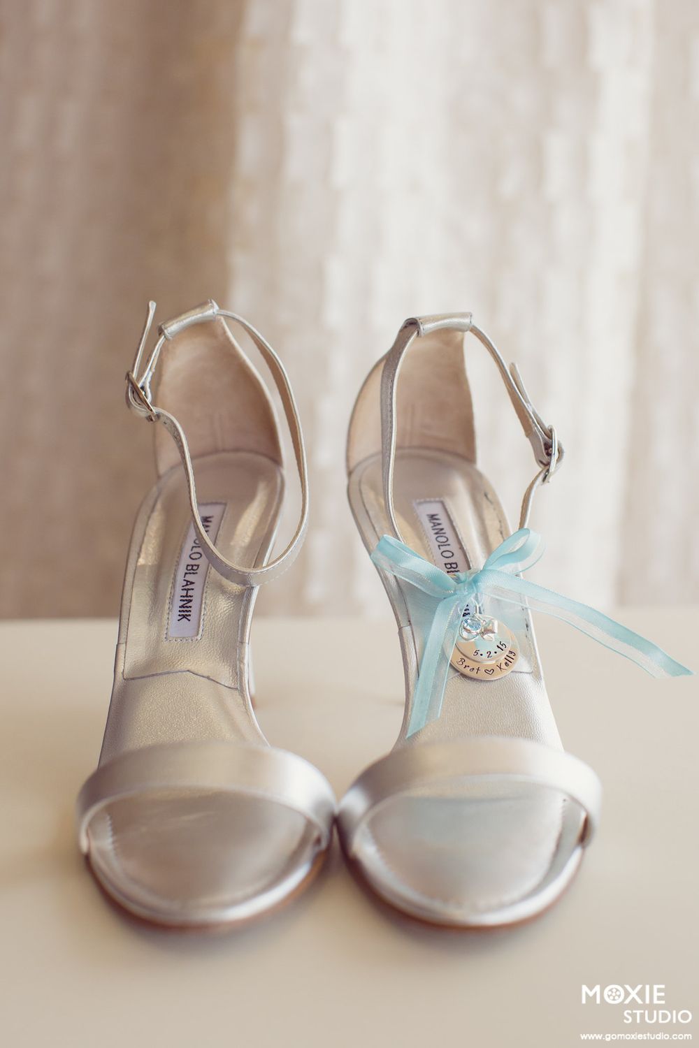 Silver bridal sandals with blue ribbon and charm detail.