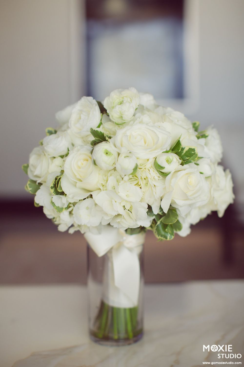 Elegant white rose and hydrangea wedding bouquet displayed in multiple angles against a soft blurred background.