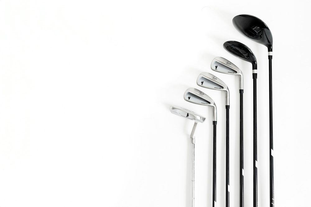 A collection of golf clubs arranged in ascending order against a white background from Small business product photoshoot for branding