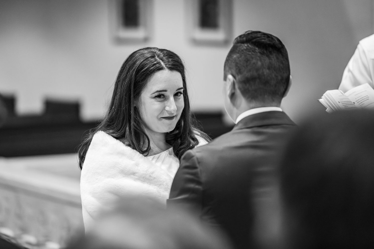Black and white photo of a couple sharing an intimate moment during a wedding celebration.