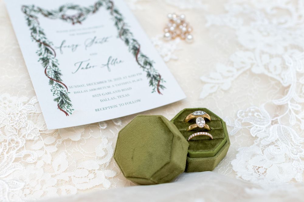 Wedding invitation suite with olive green velvet ring box and delicate floral design on white lace background.