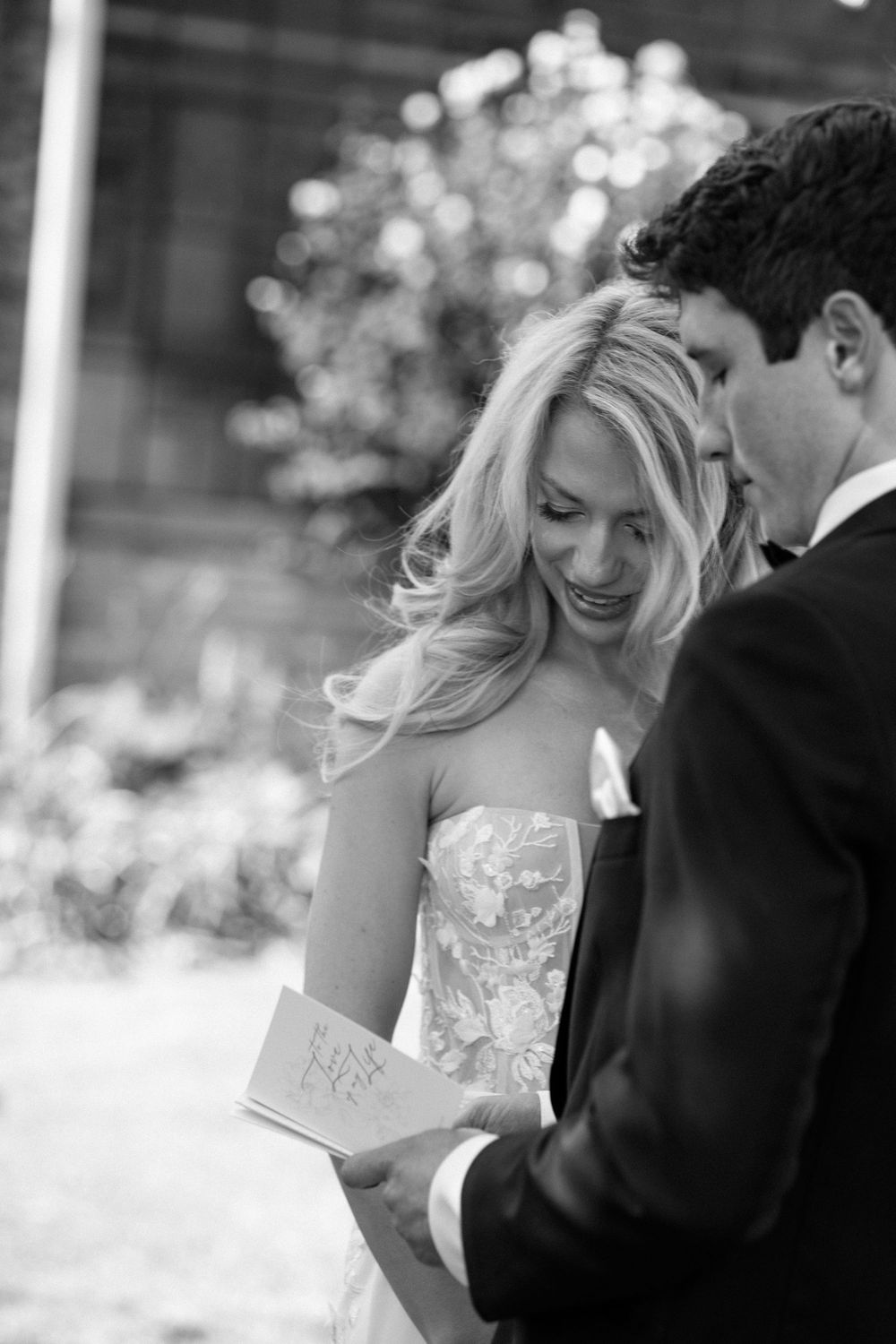 Black and white photo of a couple sharing laughter during their wedding celebration.