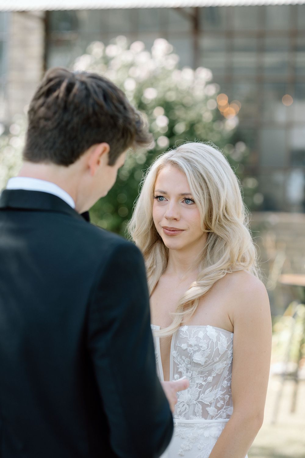 Candid wedding moment captured in natural light with soft bokeh background.