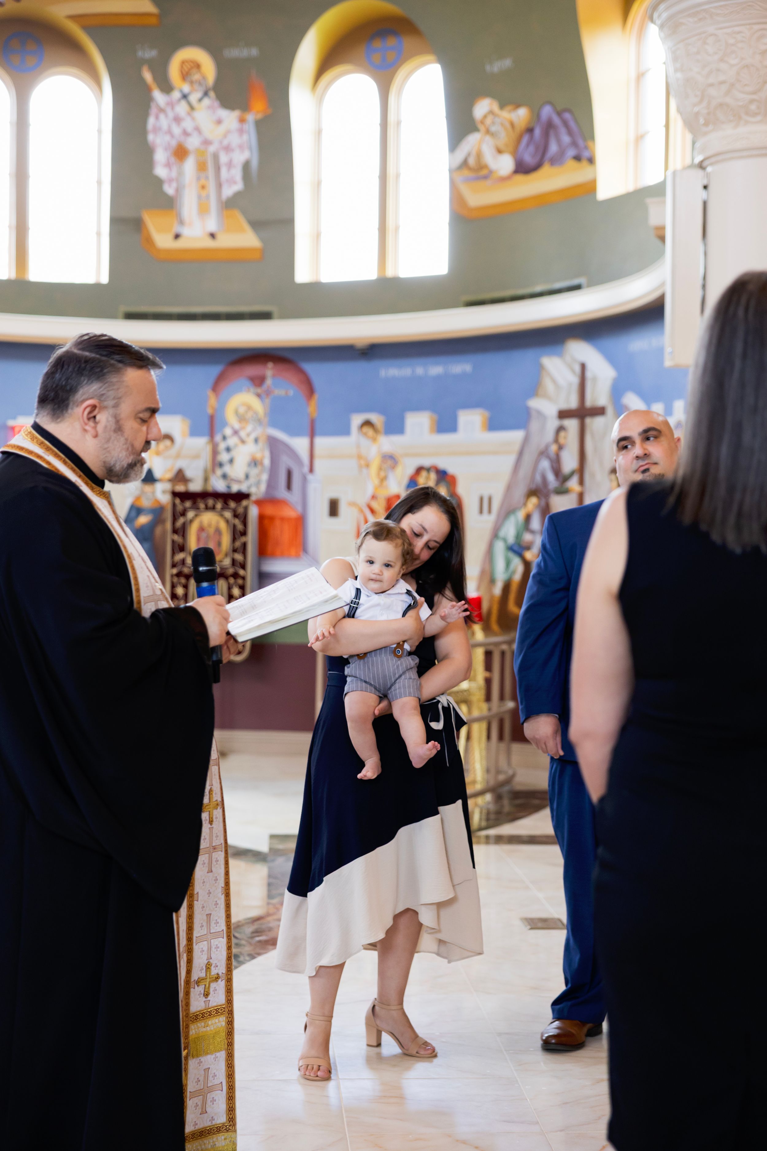 A sequence of photos showing a baptism ceremony taking place inside an ornate church with painted walls and arched windows.