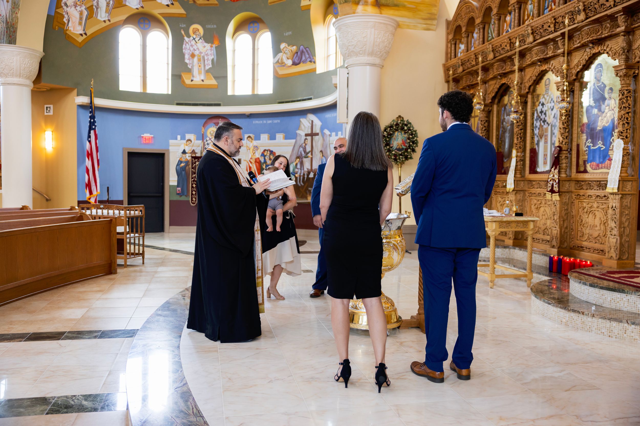 Wedding party poses in elegant church interior with ornate architecture and stained glass windows.