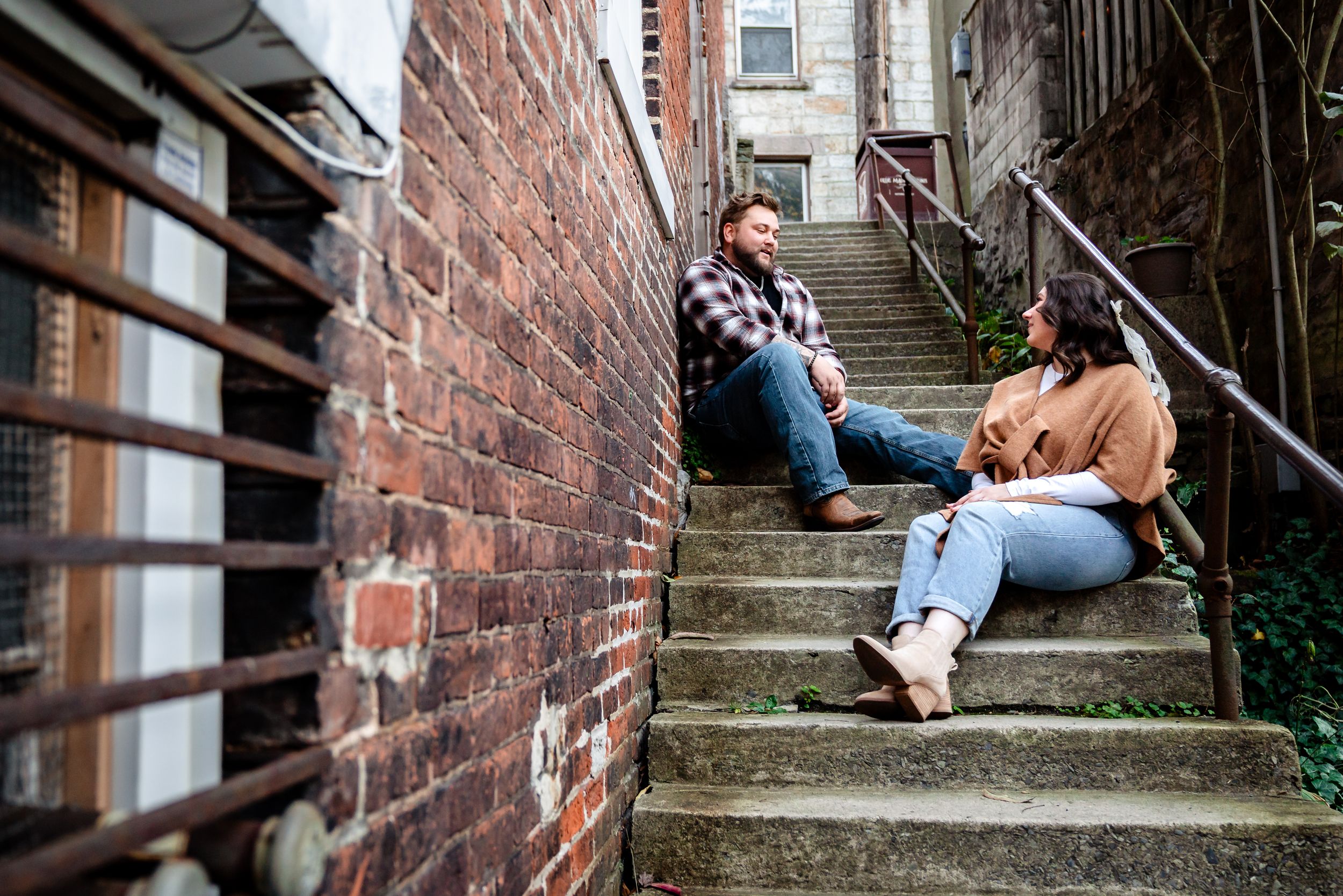Urban engagement photoshoot on brick stairway with natural lighting.