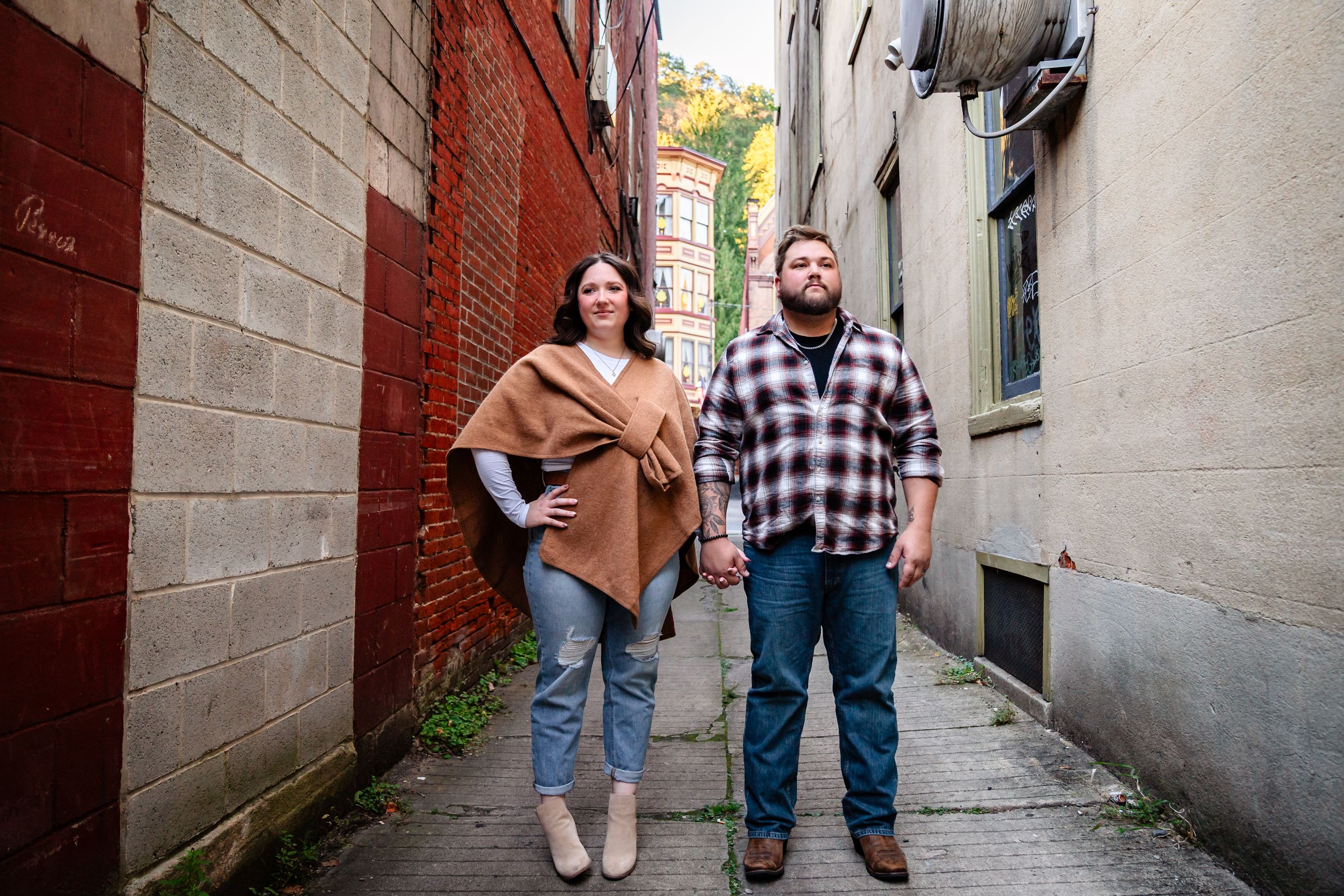 Romantic photo series in a narrow urban alleyway with brick walls.