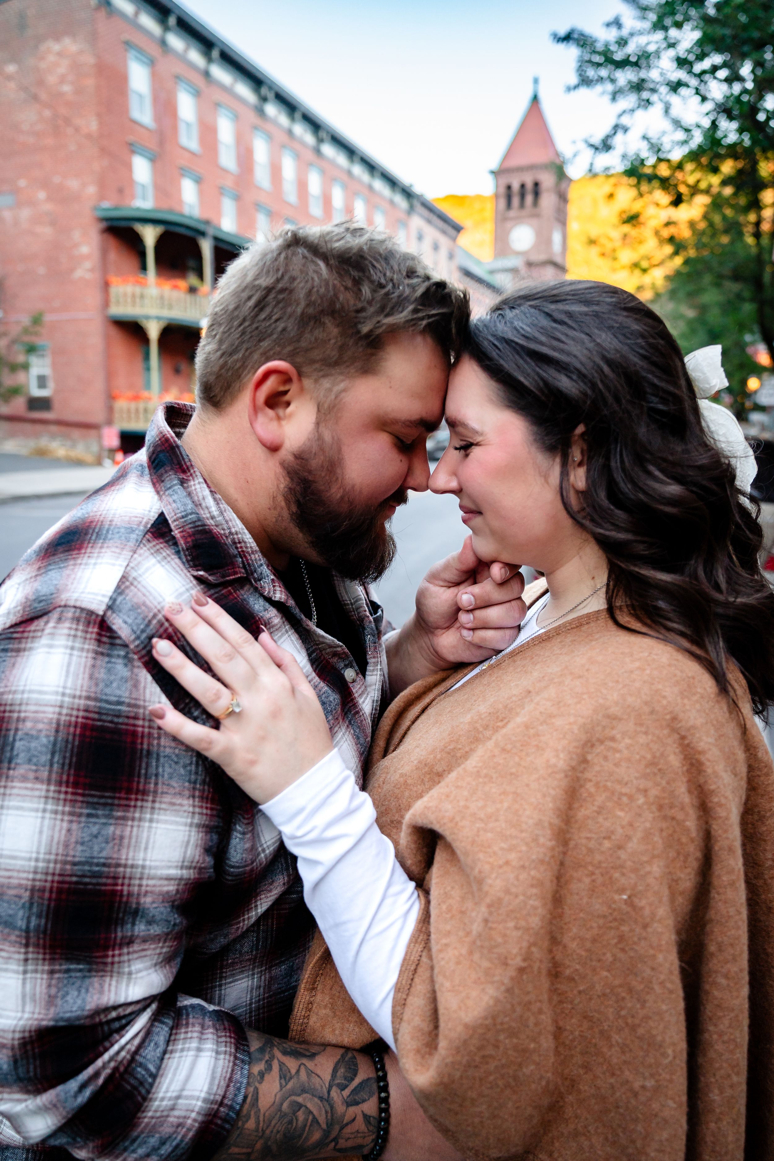 Intimate moments captured against historic brick buildings during golden hour.