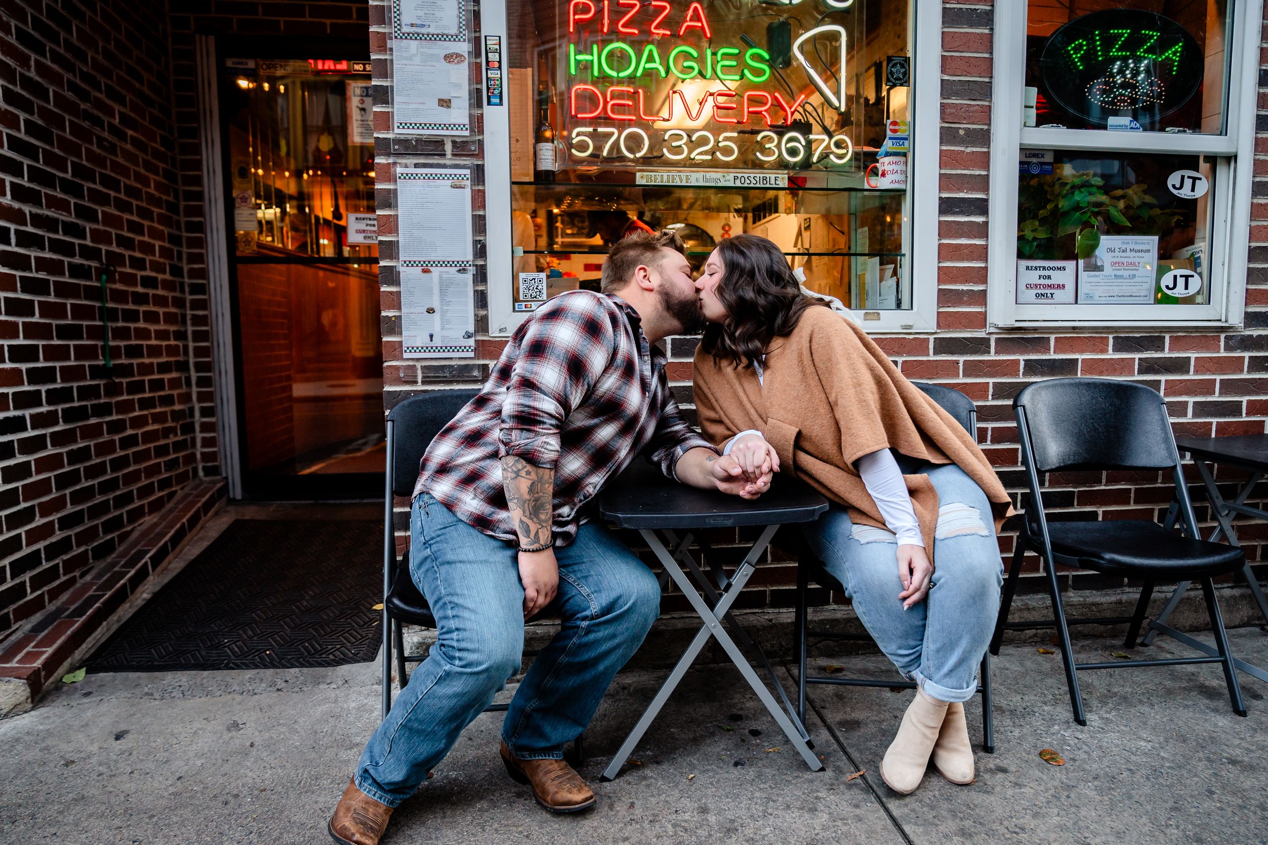 Casual street photography session outside a pizza shop with brick backdrop.